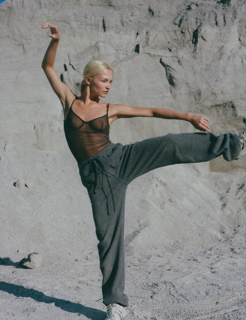 Woman modeling Ernest Leoty clothing in a rugged, rocky landscape, highlighting movement and style.
