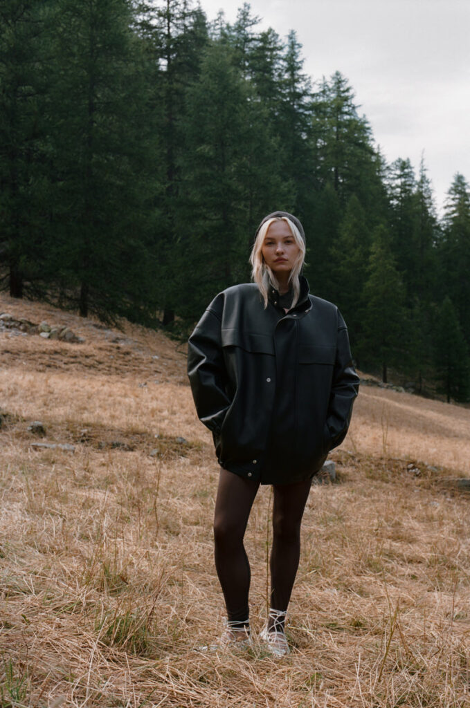 Woman modeling Ernest Leoty clothing in a dry forest landscape, highlighting style and coziness.