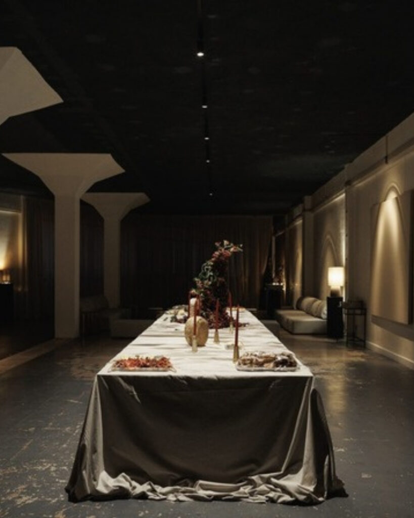 A long candlelit table set for First Editions à mesa