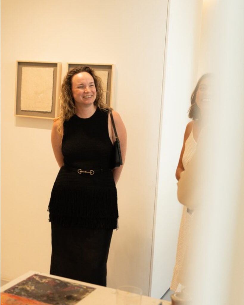 A visitor smiles in a gallery during Lisbon Art Weekend
